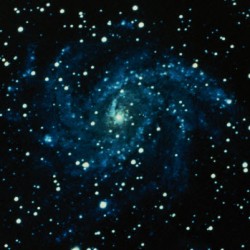 A vibrant spiral galaxy surrounded by numerous bright stars in deep space.