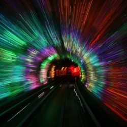 A colorful tunnel with vibrant, streaking lights creating a dynamic, futuristic visual effect.