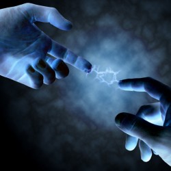 Two glowing blue hands reaching out with fingers touching in a dark, misty environment.
