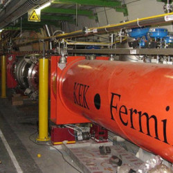 Interior view of the Fermi particle accelerator with its large orange beamline and surrounding machinery.
