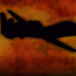 Silhouette of a helicopter against a fiery orange and red sky at sunset.